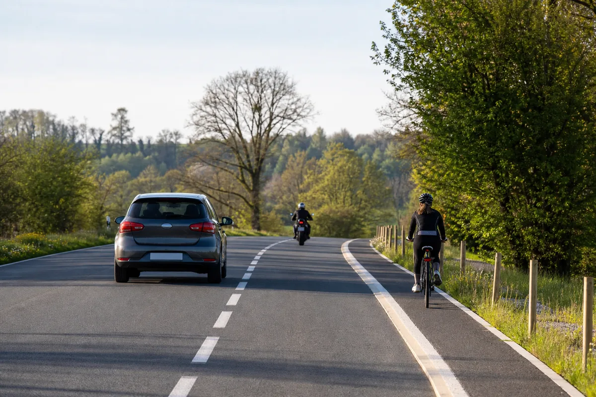 Voiture, moto et vélo sur une route de campagne pour la sécurité routière 2026